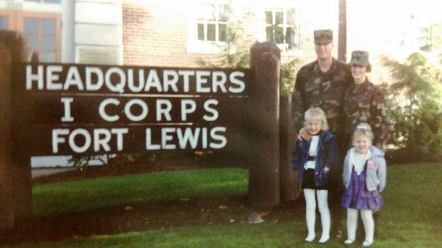 The Kendall family poses by the Fort Lewis sign